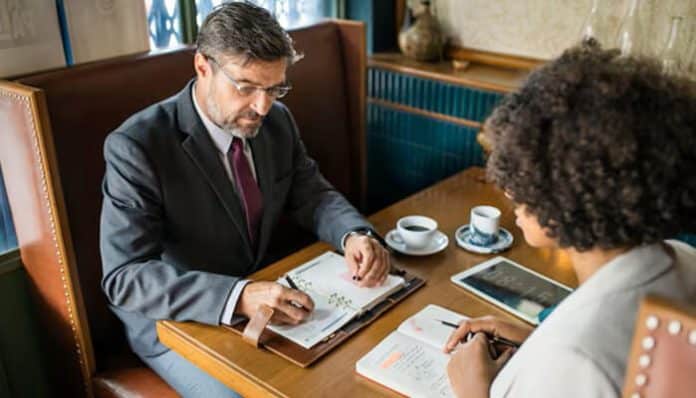 An attorney and client discussing legal matters at a café, representing a private and confidential attorney-client meeting under attorney-client privilege.