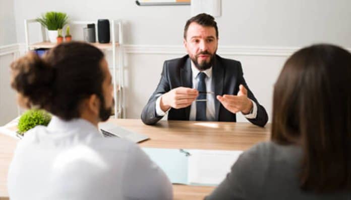A divorce lawyer explaining the legal process to clients during a consultation meeting.