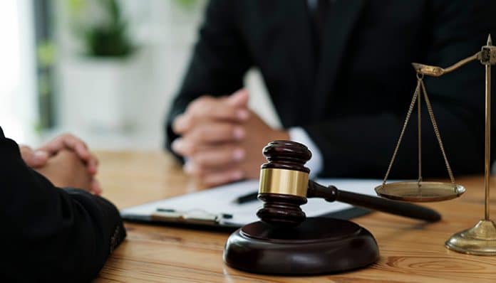A criminal defense attorney consulting with a client, with a gavel and scales of justice on the table, symbolizing legal representation in criminal cases.