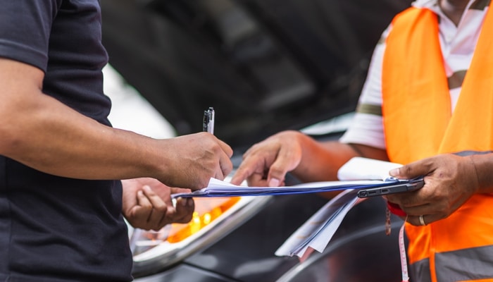 What to do when Dealing with Car Problems - Myleagalopinion - My Legal Opinion Dealing with a defective vehicle: Two individuals reviewing documents related to car repair, showcasing the importance of documenting issues and repairs when handling defective vehicles.