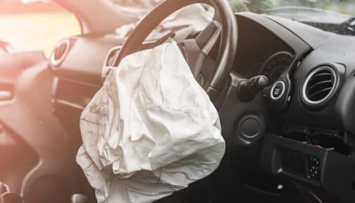 Deployed airbag inside a damaged vehicle after a minor car accident.