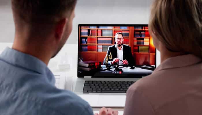 Written and Digital Communications - Myleagalopinion - My Legal Opinion A couple engaging in a virtual meeting with an attorney on a laptop, highlighting the confidentiality of attorney-client privilege in online consultations.