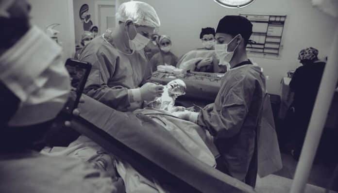 Medical team performing an assisted delivery in a hospital setting, highlighting potential Assisted Delivery Complications during childbirth.