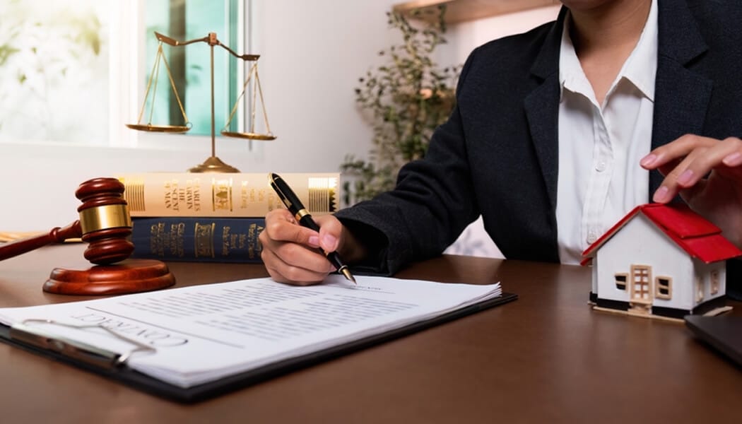 Estate Planning Lawyer - Mylegalopinion - My Legal Opinion A lawyer reviewing legal documents related to real estate, illustrating the role of property lawyers in handling legal transactions and disputes in property law.