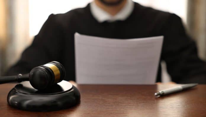 Assault Charges in Idaho illustrated by a judge reviewing legal documents with a gavel on the desk during a criminal case