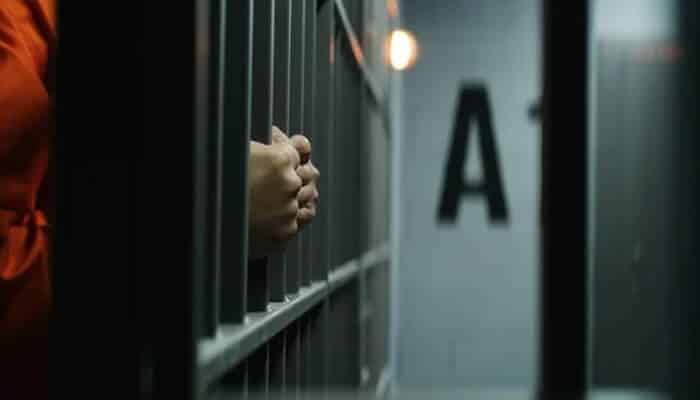 Immediate Steps to Take After an Arrest - Mylegalopinion 1 - My Legal Opinion Person's hands gripping the bars of a jail cell during spouses ICE detention.