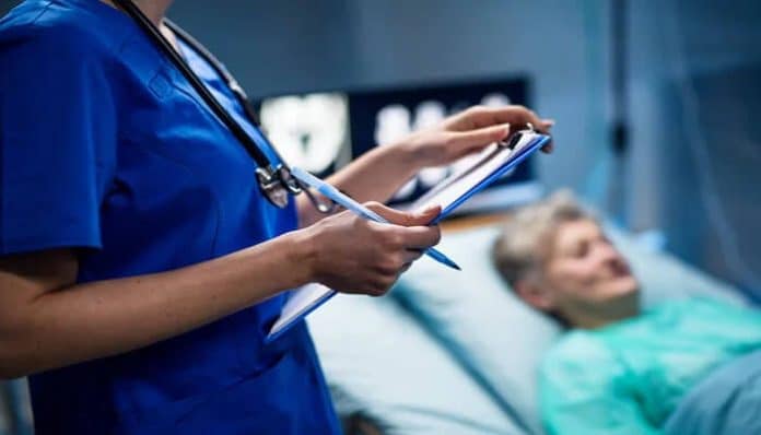 Nurse reviewing medical records beside a hospitalized patient, illustrating medical negligence and patient harm during clinical care.