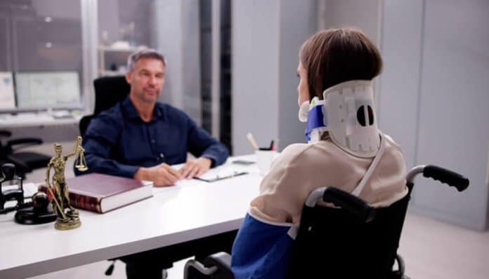 Employee with a neck brace meeting a legal professional after a Job Injury in Minnesota to discuss workers’ compensation benefits and claim options.