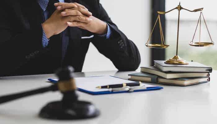 The Ultimate Guide to Lawyer SEO How to Improve Your Law Firms Search Rankings - Myleagalopinion - My Legal Opinion A lawyer sitting at a desk with legal books and a gavel, emphasizing the importance of Law Firms Search Rankings and Lawyer SEO for improving online visibility and attracting clients.