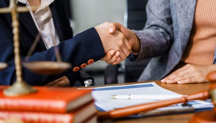 Corporate governance - My Legal Opinion - My Legal Opinion Business professionals shaking hands over legal paperwork, illustrating what are Articles of Incorporation in corporate agreements and registration