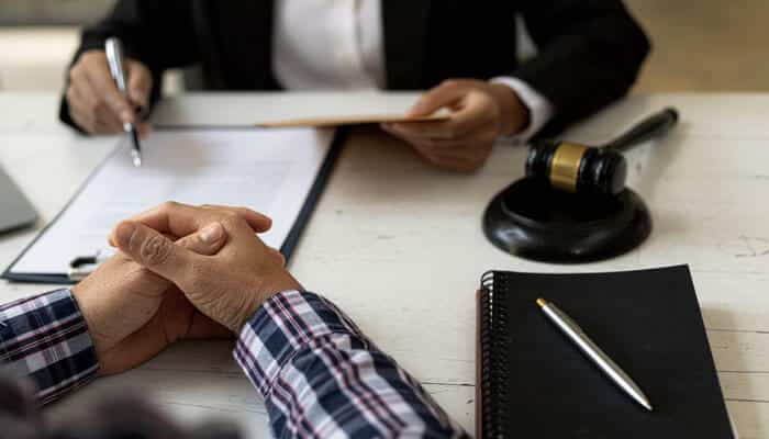 File a Lawsuit - Myleaglopinion - My Legal Opinion Catastrophic Injury Lawyer assisting a client with legal documents during a consultation, discussing a serious injury claim.