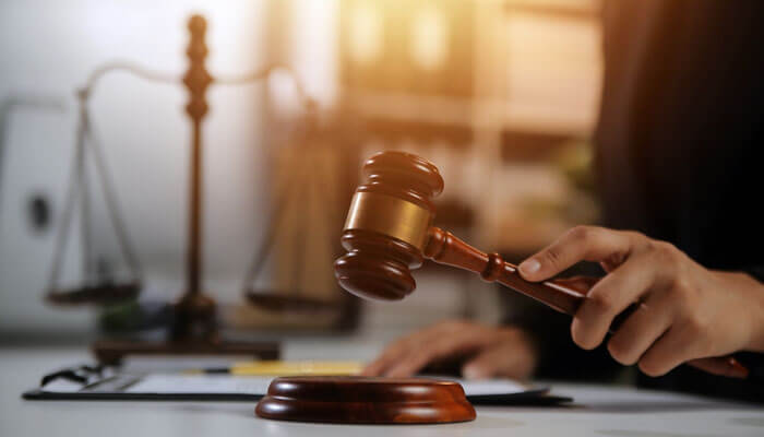 Hiring an attorney - My Legal opinion - My Legal Opinion Close-up of a gavel with legal scales in the background, representing the legal proceedings and justice system in cases of Sex Crimes Against Minors.