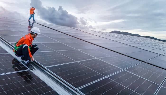 Installation problems - My Legal Opinion - My Legal Opinion Solar workers installing large solar panels on a rooftop, representing labor and safety issues cited in the Momentum Solar lawsuit