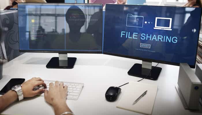 Steps to Evaluate and Test Potential Solutions - My Legal opinion - My Legal Opinion Professional workspace with dual monitors displaying file sharing solution software for secure data transfer and collaboration