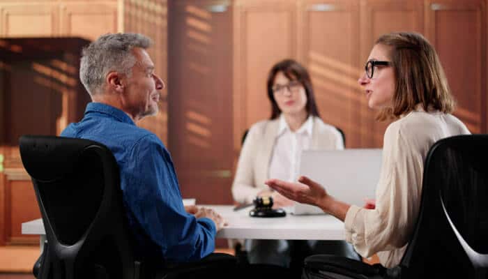 When Domestic Violence Is Present - My Legal Opinion - My Legal Opinion Family litigation in progress: a couple discussing with a lawyer in a mediation session, seeking resolution for family-related legal issues.