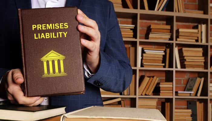 Why You Need a Premises Liability Attorney - mylegalopinion - My Legal Opinion Premises Liability Lawyer A professional holding a "Premises Liability book, emphasizing the legal expertise needed for property injury claims.