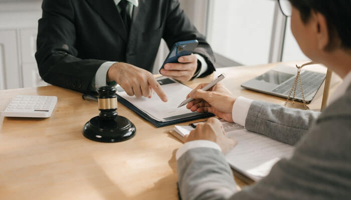 Commercial thinking not just legal thinking - My Legal Opininon - My Legal Opinion A legal consultation between two professionals, one pointing to a document while discussing important details with the other. A strong example of how to hiring a lawyer for your case.