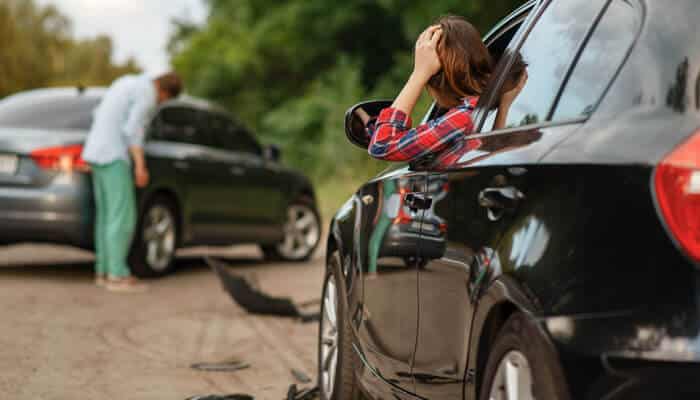 A woman sitting in her car after a collision, looking distressed. A typical car accident scene in Las Vegas Uber Accident Lawyer vs. Regular Car Accident Lawyer