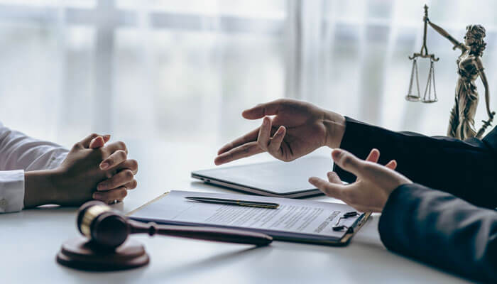 The Advantage of Professional Legal Guidance - My Legal Opinion - My Legal Opinion A legal consultation for a workers' compensation claim in Georgia. A lawyer explains legal documents to a client in an office with a gavel and legal scales in view.