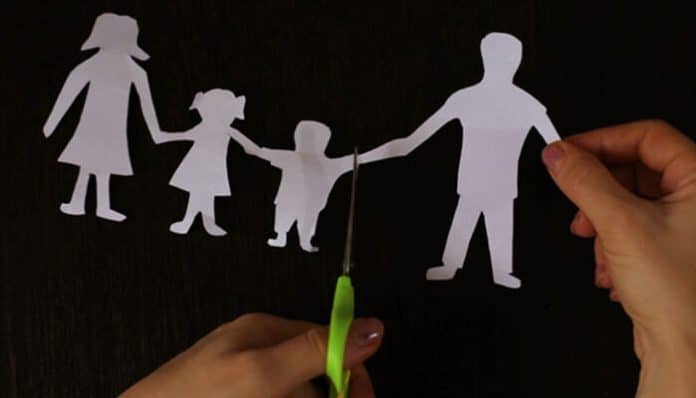 A symbolic image of a family being separated by scissors, representing the impact of domestic violence and family law in the context of legal battles. A Domestic Violence Lawyer can help navigate such cases.