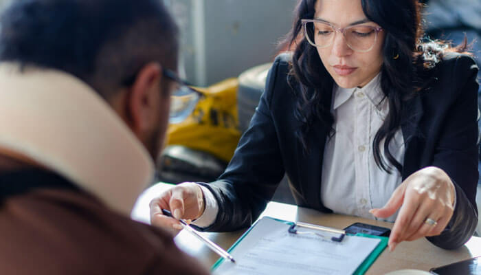 What Is Your Track Record with Settlements and Verdicts - My Legal Opinion - My Legal Opinion Premises liability lawyer meeting with a client who has an injury, reviewing legal documents, and discussing potential legal action for property-related accidents.