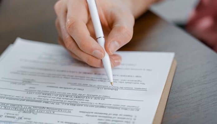 Signing a Legal Contract on an official document with a pen during a formal agreement process